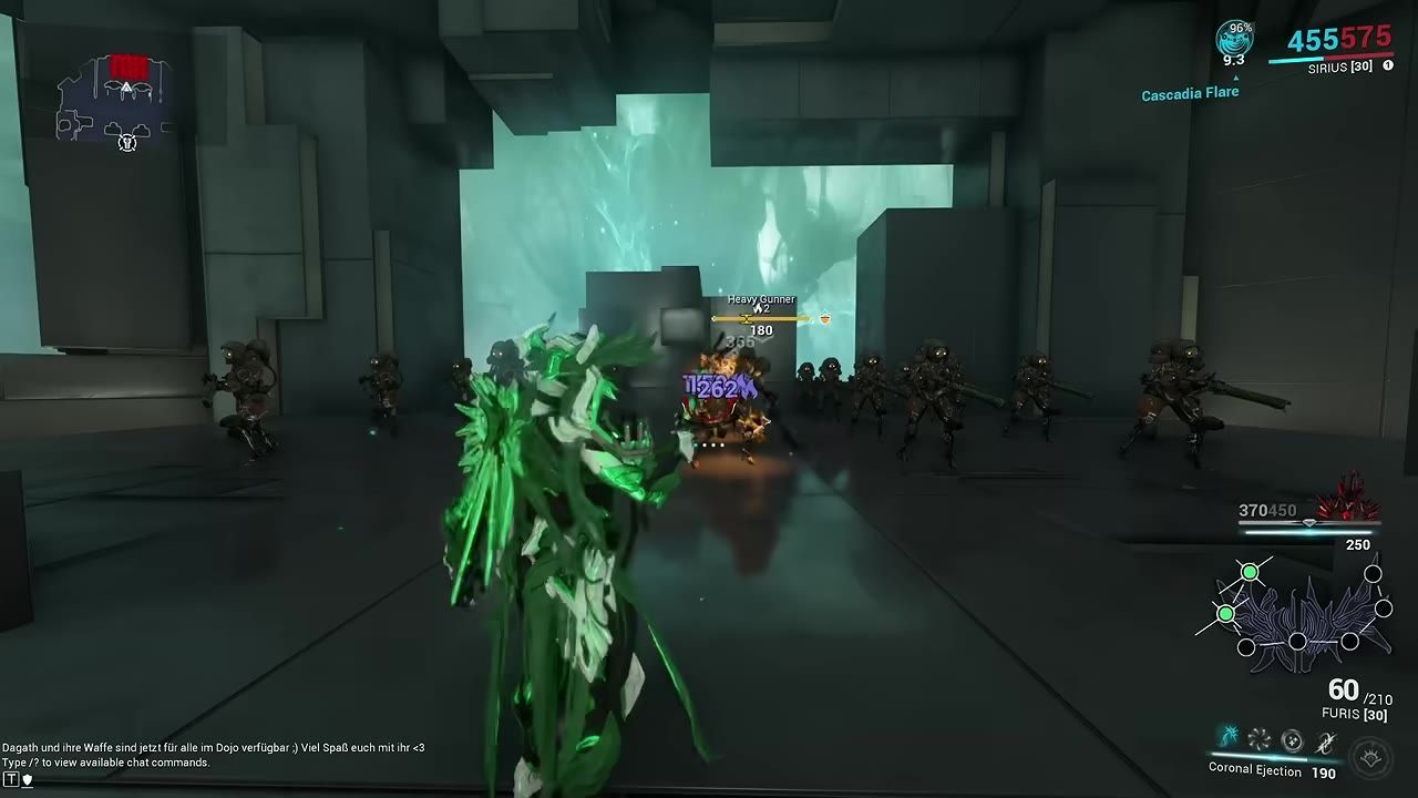 A character in green armor engages enemies in a futuristic setting, displaying damage and abilities on screen.