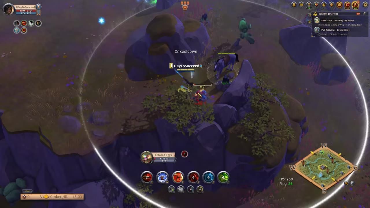 A game character fighting enemies in a rocky outdoor area marked in a yellow zone.